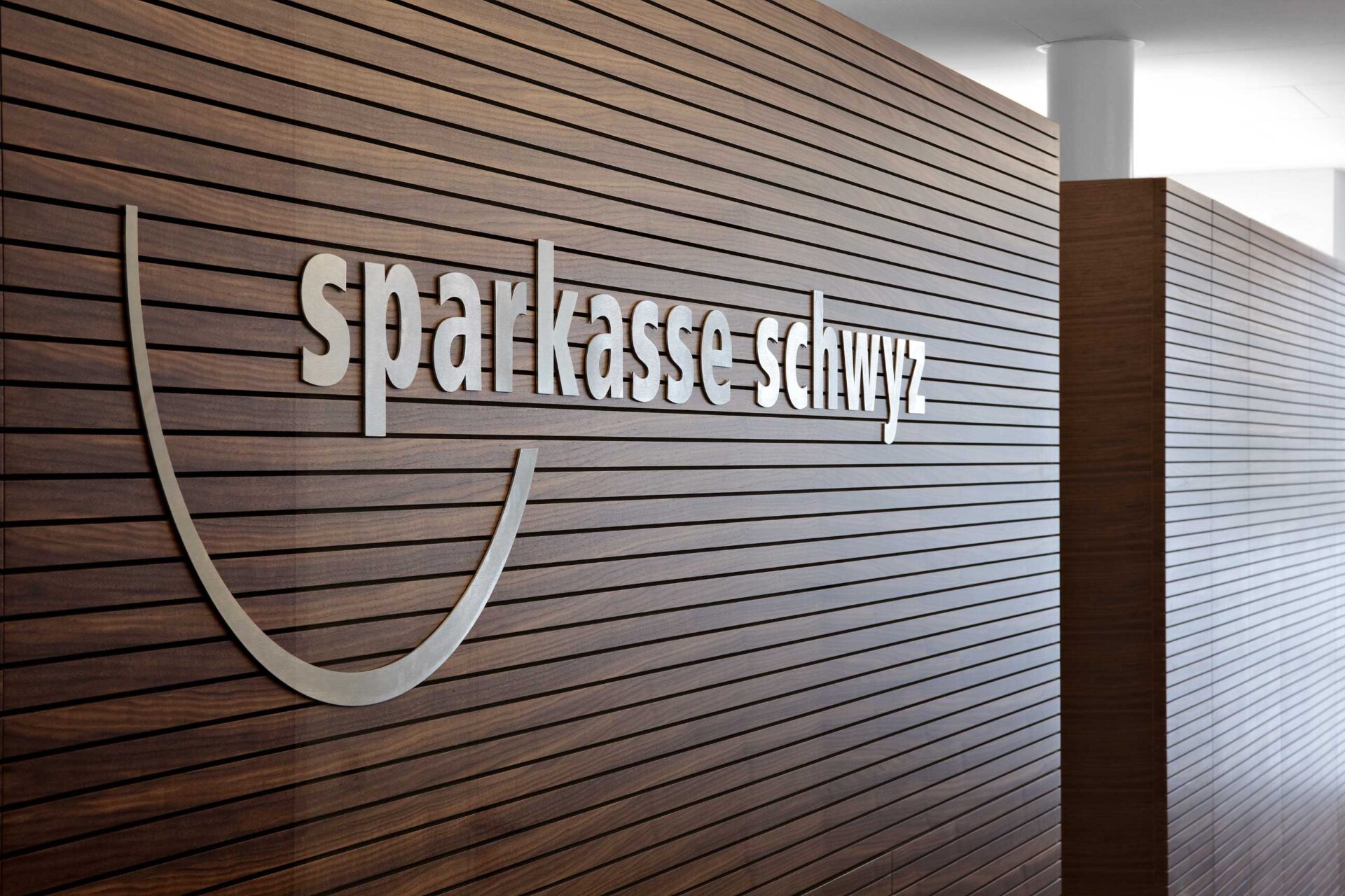 Sparkasse Hauptplatz Schwyz, Logo an Holzwand, marty architektur