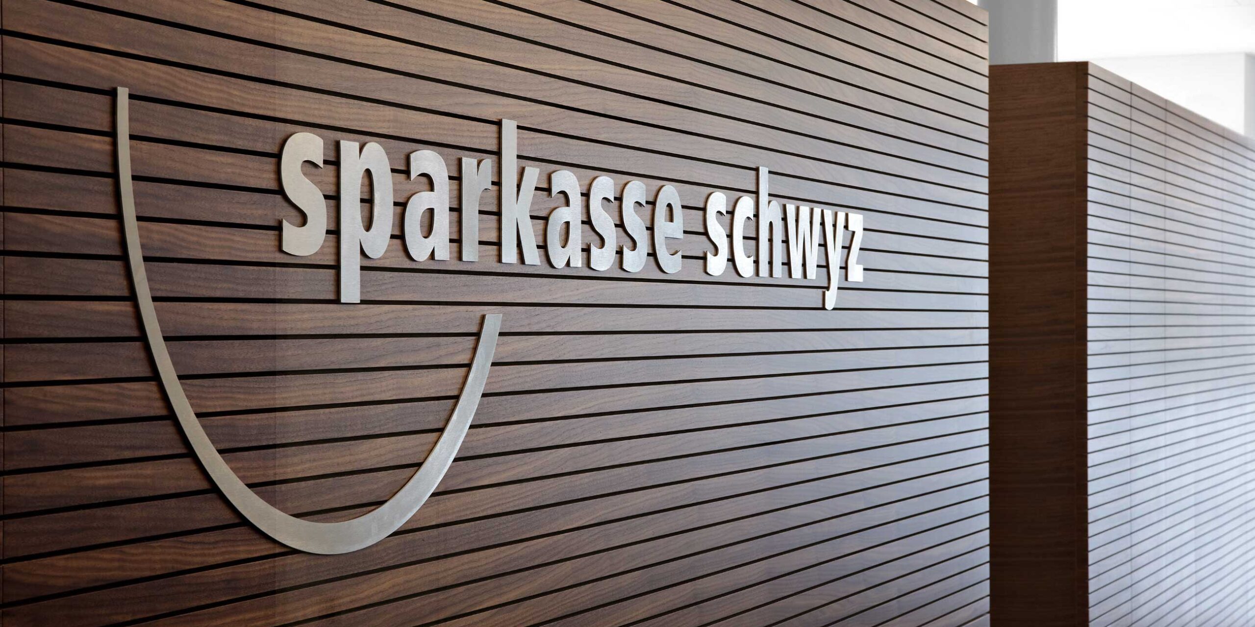 Sparkasse Hauptplatz Schwyz, Logo an Holzwand, marty architektur